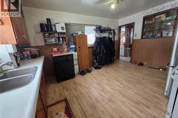 Another angle of the kitchen with sink, dishwasher, and storage cabinets - 5460 Kings Avenue, Gull Lake
