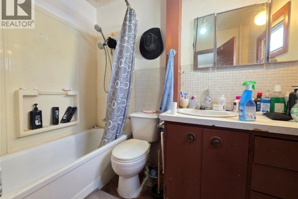Bathroom with bathtub, shower curtain, and vanity with sink and mirror - 5460 Kings Avenue, Gull Lake
