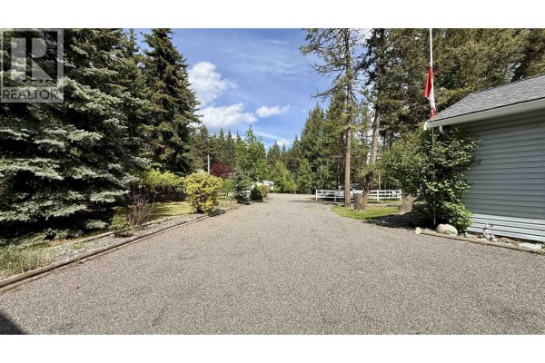 Expansive view of the landscape from the property, showcasing trees and open fields. - 5466 Donsleequa Court, 108 Mile Ranch
