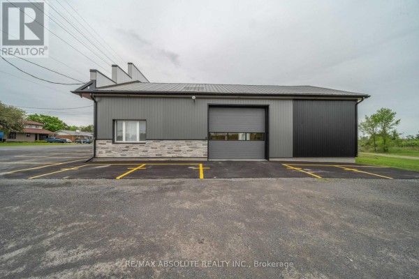Rear exterior of commercial building with one large grey garage door and grey siding. - 547 County Rd 9 Road, Alfred And Plantagenet