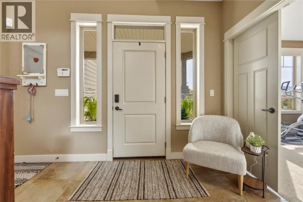 Interior view of a staircase with beige carpet treads and a dark brown wooden handrail with black spindles. - 547 Mt. Tanner Place, Coldstream