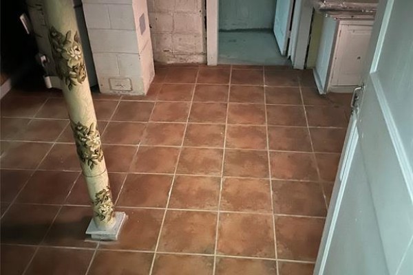 Room with terracotta square tile flooring, a decorative column, and concrete walls. - 547 Pierre Avenue, Windsor