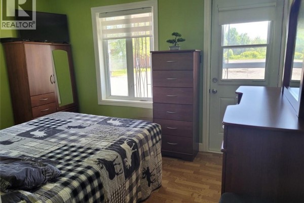 Dark wood cabinetry and kitchen appliances including stove, microwave, and dishwasher with wood-look flooring. - 547 Principale Street, Saint Basile