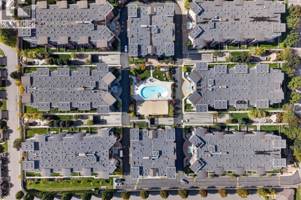 Aerial overview of a condo complex with multiple buildings surrounding a central courtyard. - 547 Yates Road Unit# 211, Kelowna