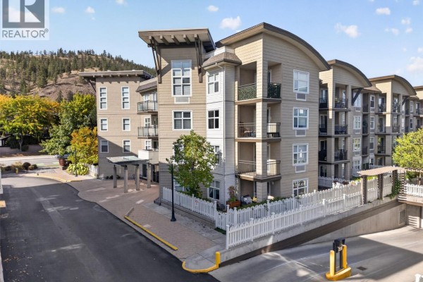 Exterior view of a modern apartment building with beige siding and balconies. - 547 Yates Road Unit# 211, Kelowna