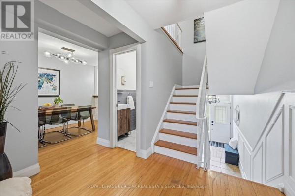 Interior view of a townhouse showing a staircase, entryway, and open doorway to dining room. - 5474 Schueller Crescent, Burlington