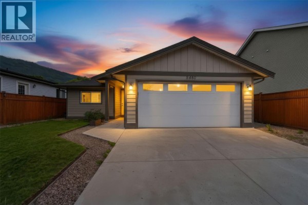 Covered patio with orange concrete floor and sliding glass door leading into the house. - 5480 Canoe Beach Drive Ne, Salmon Arm