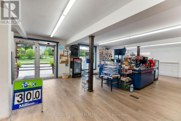 Interior store view with a checkout counter, merchandise displays, and entrance doors with signage. - 5480 Highway 620, Bancroft