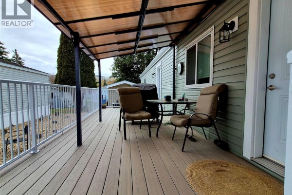 Covered deck with seating and table, overlooking the yard - 5484 Okanagan Landing Road Unit# 51, Vernon