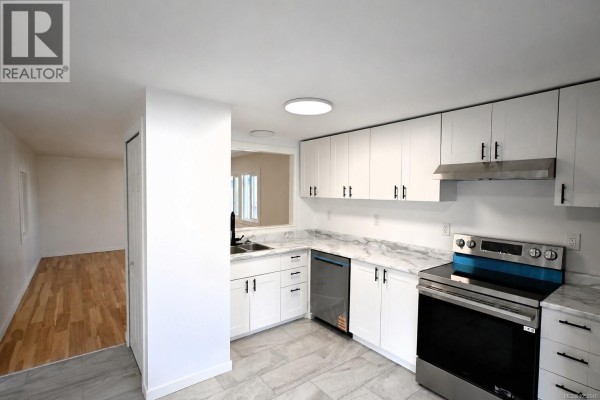 Small room with light-colored walls, hardwood floors, and a single window. - 55 1000 Chase River Rd, Nanaimo