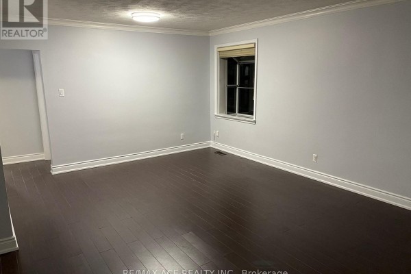 Empty room with dark wood floors, light grey walls, and one window. - 55 Brenda Crescent, Toronto