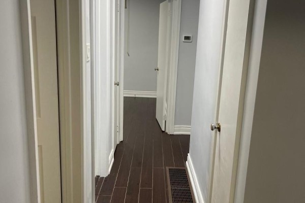 Hallway with dark wood floors, white doors, and grey walls. - 55 Brenda Crescent, Toronto