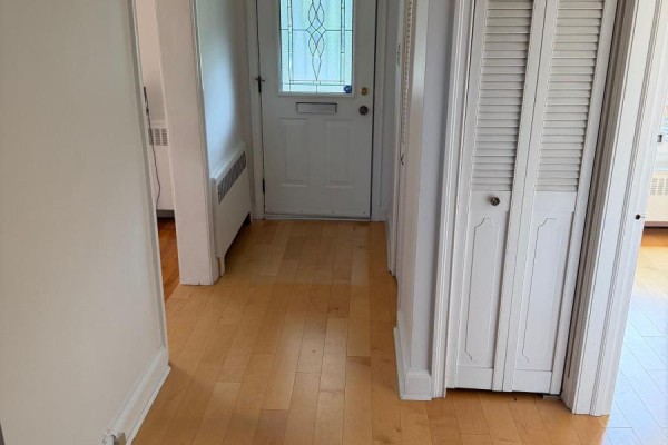 Hallway with light wood floors, a white front door with decorative glass, and white bi-fold closet doors. - 55 Craigmore Crescent, Toronto