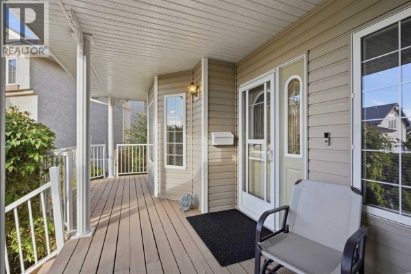 Close-up of the front entrance showing the house number 55, beige siding, and stone accents. - 55 Dietz Close, Red Deer