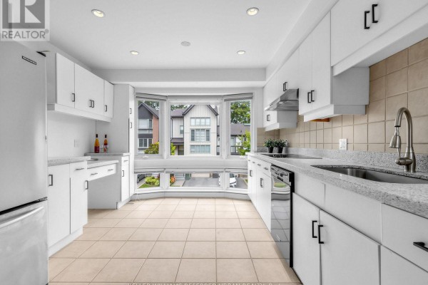 Bright white kitchen with stainless steel appliances, granite countertops, and a bay window. - 55 English Ivyway, Toronto