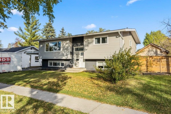 Street view of the front of a raised bungalow with a detached garage and mature trees. - 55 Gladstone Cr, St  Albert