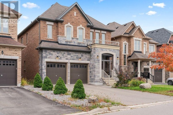 Side view of the house facade showcasing the brickwork, stone accents, and double garage doors. - 55 Marbrook Street, Richmond Hill
