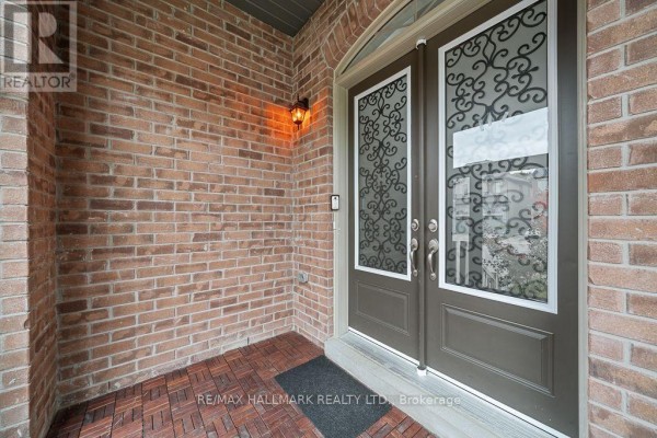 Brick exterior of the covered porch with double doors and a wall-mounted light fixture. - 55 Marbrook Street, Richmond Hill