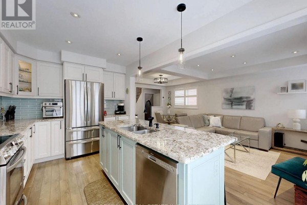 Modern kitchen island, stainless steel appliances, and open living space - 55 Stocks Lane Aurora