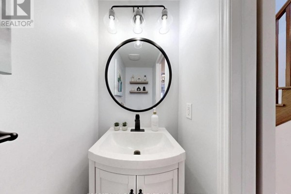 Modern bathroom vanity with round mirror and three-light fixture - 55 Stocks Lane Aurora