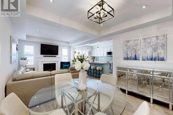 Living room with fireplace, sectional, dining table, and open kitchen - 55 Stocks Lane Aurora