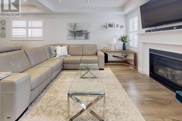A primary bedroom with a king-size bed, dressers, a bench, and a doorway leading to an ensuite bathroom. - 55 Stocks Lane, Aurora