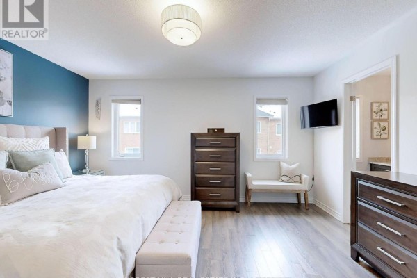 King bed, accent wall, mounted TV in bedroom - 55 Stocks Lane Aurora