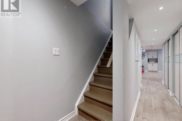 Hallway with wood staircase, light wood flooring, and closet doors - 55 Stocks Lane Aurora