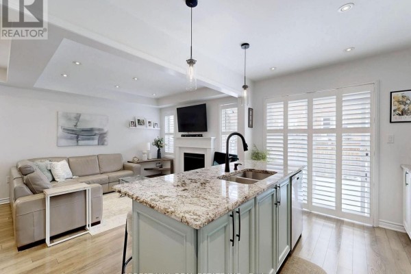 Kitchen island with granite counters, sofa, and fireplace - 55 Stocks Lane Aurora