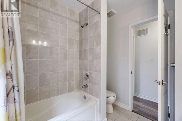 Bathroom with bathtub, shower, toilet & floral curtain - 55 Stocks Lane Aurora