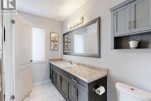 Bathroom with double vanity, granite counters, large mirror, and modern lighting - 55 Stocks Lane Aurora