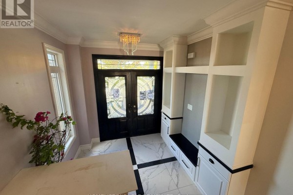 Foyer with double glass doors, marble tile floor, and built-in white shelving unit with bench seating. - 55 Treetops Boulevard, New Tecumseth