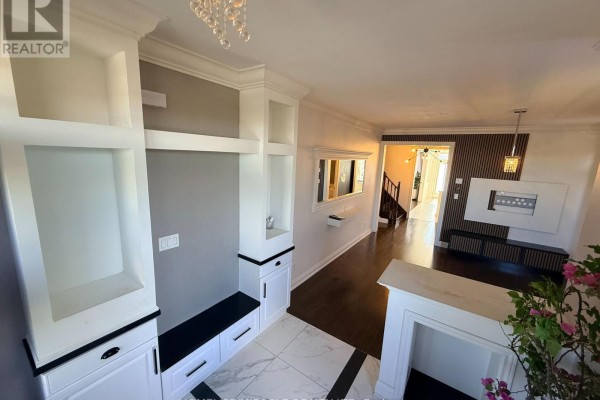 Interior view showing foyer built-ins, hallway with dark wood floors, and view into dining area. - 55 Treetops Boulevard, New Tecumseth