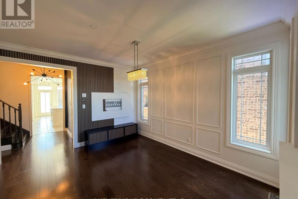 Dining room with dark wood floors, decorative molding, modern chandelier, and view into hallway. - 55 Treetops Boulevard, New Tecumseth
