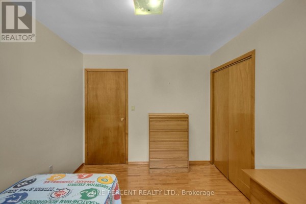 Bedroom with wooden doors, chest of drawers, and football bedding - 55 Young Street Tillsonburg