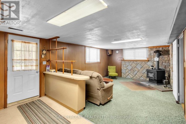 Basement with bar, sofa, armchair, and wood stove - 55 Young Street Tillsonburg