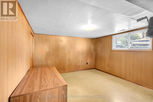 Wood-paneled basement room with window and cabinet - 55 Young Street Tillsonburg