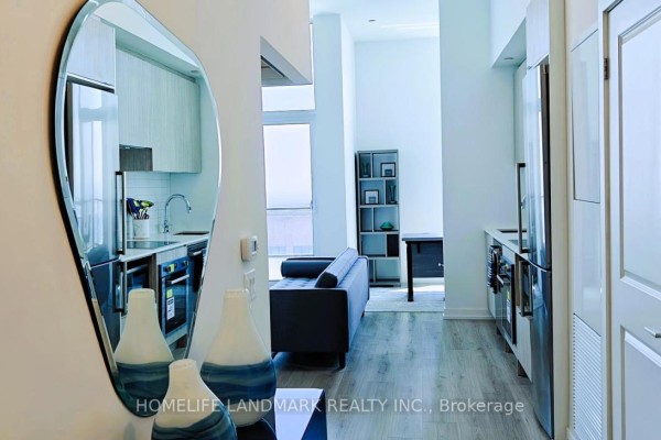 View of the kitchen and living area with a decorative mirror in the foreground. - 5501 - 395 Bloor Street W, Toronto