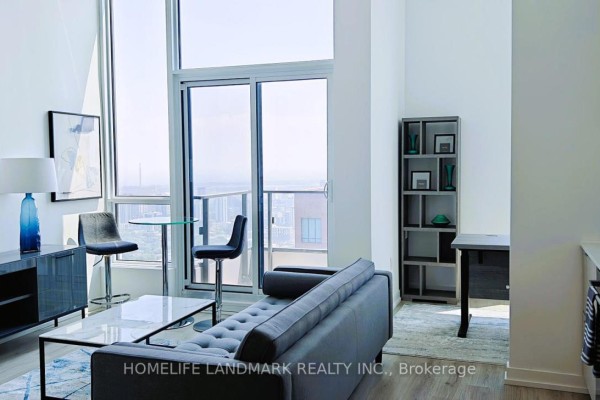 Sofa, coffee table, and dining set in front of large windows with city views. - 5501 - 395 Bloor Street W, Toronto