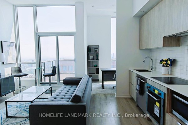 Open concept living area and kitchen with modern appliances and city views. - 5501 - 395 Bloor Street W, Toronto