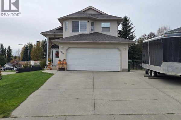 Front exterior of a two-story house with a double garage and a concrete driveway. - 5501 17 Avenue, Edson