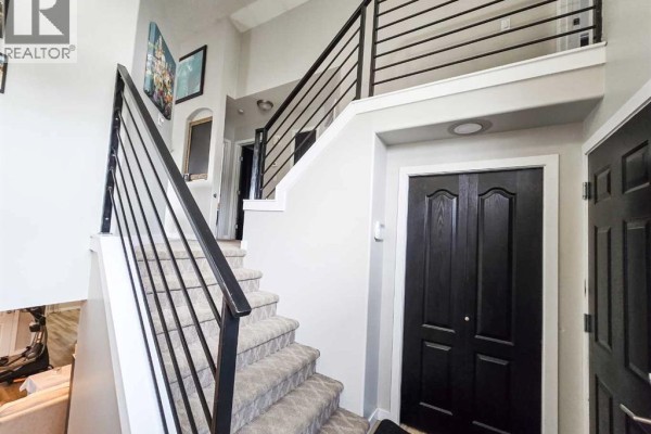 Interior staircase with plush carpeted stairs and a modern black metal railing system. - 5501 17 Avenue, Edson