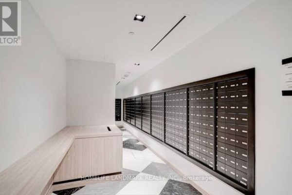Hallway with a long wall of mailboxes and a wooden counter on the left. - 5509 - 395 Bloor Street E, Toronto