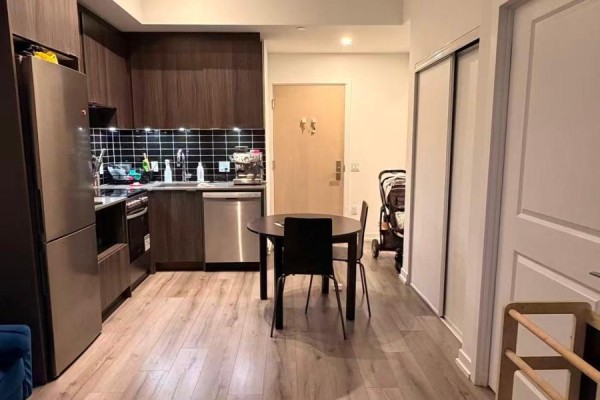 Kitchen with dark wood cabinets, stainless steel appliances, and a tiled backsplash. - 5509 - 395 Bloor Street E, Toronto