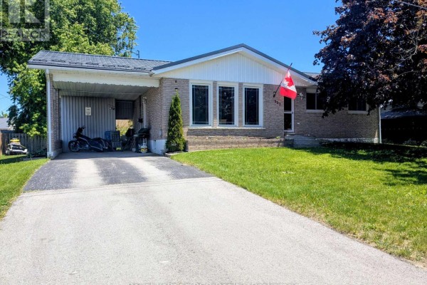 Front exterior of a light brick bungalow with a metal roof and covered carport. - 551 15th Avenue, Hanover