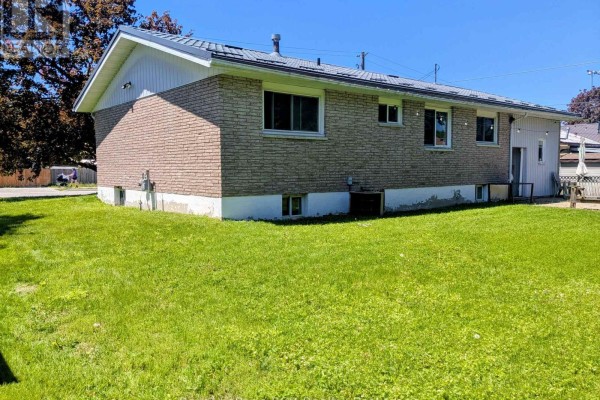 Rear exterior of a light brick house with a green lawn and white siding. - 551 15th Avenue, Hanover