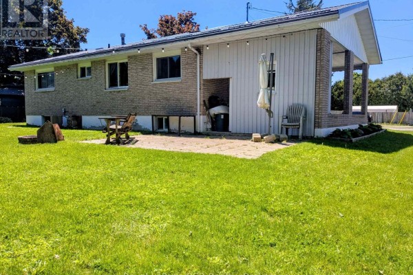 Back patio with a wooden picnic table and chairs next to a grassy lawn. - 551 15th Avenue, Hanover