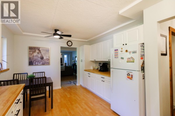 Dining area with a small table, four chairs, and a window overlooking greenery - 5515 Kleanza Drive, Terrace