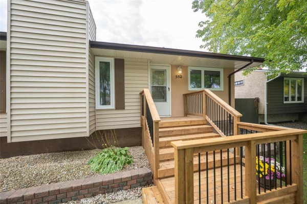 Close-up of the wooden porch and steps leading to the front door of the house. - 552 Ravelston Avenue W, Winnipeg