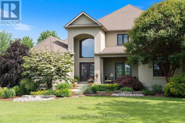 Detailed view of the front doors with decorative glass and red flowers in pots nearby. - 55226 Best Line, Bayham